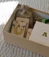 Collar con dije de herradura dorada y cordón celeste.