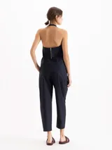 Pantalón slouchy de poplín color beige, de calce regular y largo al tobillo, con tablas en el delantero y ruedo que aportan volumen, bolsillos laterales y cierre con botones tipo honguito.