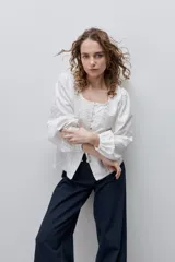 Pantalón jean de tiro alto y pierna wide leg, color azul oscuro, con diseño de cinco bolsillos, pasacintos y cierre frontal con botón.