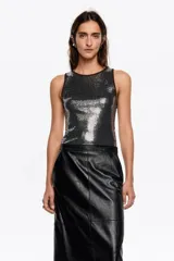 Top sin mangas de corte ajustado con escote redondo, confeccionado en tejido con lentejuelas brillantes y vivos en contraste en el cuello y las sisas.