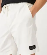 Bermuda masculina color gris claro, de sarga con efecto jaspeado, cintura elástica ajustable con cordón, bolsillos laterales y traseros, y etiqueta en la barra.