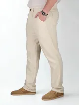 Pantalón de lino color beige, de corte recto, con bolsillos laterales y traseros. Se ajusta a la cintura con cinturón de cuero marrón.