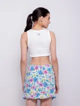 Minifalda estampada con flores en tonos celeste, azul, rosa y amarillo, con volados en el frente y cierre invisible en la parte trasera.