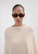 Poncho de punto con diseño de capa, asimétrico, cuello barco y manga tres cuartos.
