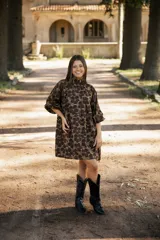 Vestido corto de lino con estampado floral en tonos tierra, verde y marrón. Presenta cuello redondo, mangas tres cuartos con volumen y silueta holgada.