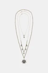 Set de tres collares de diferentes largos, con cadenas de eslabones finos y detalles de bolitas metálicas en tonos dorados y plateados. Incluye un colgante principal en forma de estrella con incrustaciones de cristales y múltiples dijes colgantes en forma de gota con cristales.