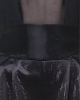 Pantalones de lúrex negros, de tiro alto con detalle de tableados en el frente, lazo detrás y cintas a la altura de los tobillos para ajuste.