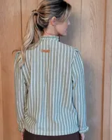 Camisa de manga larga con estampado de rayas verticales en tonos crudo y beige. Presenta cuello alto con volados, cierre frontal con botones dobles y puños con volados.