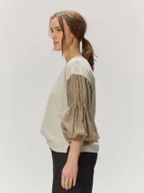 Remera blanca con cuerpo de algodón liso y mangas abullonadas semitransparentes con textura de lunares.