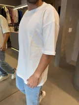 Remera de corte oversize en color blanco, confeccionada en tejido de algodón con textura acanalada, cuello redondo y mangas cortas.