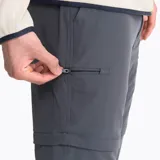 Pantalón convertible de hombre en color gris, diseñado para actividades al aire libre. Presenta un corte recto, cintura ajustable con cinturón incluido, múltiples bolsillos con cierre y tecnología repelente al agua. La prenda permite desmontar la parte inferior de las piernas para transformarse en shorts.