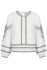 Blusa blanca de manga larga con detalles de bordados florales en tono grisáceo y bandas decorativas en el frente y mangas. Cuenta con cuello redondo y puños elásticos.