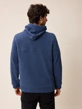 Canguro de polar azul con capucha y cordones ajustables. Presenta un bolsillo frontal tipo canguro y un pequeño logo bordado en el pecho.