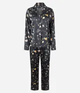 Pijama de dos piezas confeccionado en satén con estampado floral sobre fondo negro. La blusa es estilo camisa con cuello solapa, manga larga y cierre frontal con botones. El pantalón cuenta con cintura elástica y corte recto.