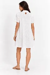 Vestido camisero midi de lino natural color blanco, con silueta fluida de línea A, cuello camisero, mangas cortas y un elaborado bordado de pedrería y cristales con diseño de estrellas en el hombro.