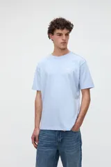 Remera marrón de manga corta con calce relajado, confeccionada en jersey de algodón pesado. Presenta una pequeña estampa con texto en el pecho y un diseño estampado en la espalda.