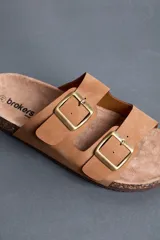Sandalias Brokers Wear de color beige, con dos tiras ajustables con hebillas metálicas doradas y plantilla anatómica.