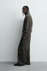 Pantalón cargo de corte relajado con efecto lavado, confeccionado en tejido de algodón. Presenta cintura elástica, bolsillos laterales de plastrón con solapa y bolsillos delanteros.