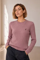 Sweater de punto con diseño de ochos, color rosado, cuello redondo y manga larga. Cuenta con un pequeño bordado en el pecho.