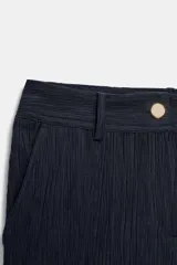 Pantalón de tiro medio con pernera recta, confeccionado en tejido con textura efecto arrugado. Cuenta con bolsillos delanteros, falsos bolsillos de vivo en la parte trasera y cierre frontal con cremallera y botón.