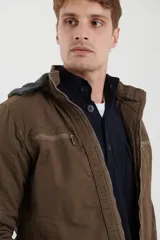 Campera técnica de tejido elástico en color azul marino, con capucha ajustable, cierre frontal y bolsillos laterales con cierre. Cuenta con forro interior de micro polar y ajuste en el ruedo.