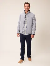 Campera softshell color gris, con cierre frontal completo, cuello alto y bolsillos laterales y en el pecho con cierre. Cuenta con logo bordado en el pecho y ajuste en los puños.