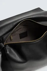 Bolso tipo bandolera de piel con acabado grabado, diseño rectangular con solapa frontal y cierre magnético. Cuenta con un asa de hombro ajustable y compartimento interior con cierre de cremallera.