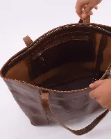 Cartera tipo tote de cuero natural, con diseño minimalista, doble asa de hombro y cierre mediante broche. Incluye bolsillo interior y porta llaves.