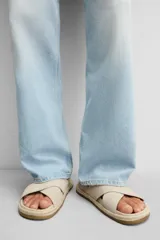 Sandalia plana color beige con dos tiras anchas cruzadas en el empeine, plantilla anatómica y suela forrada en yute.