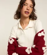 Vestido corto de color blanco hueso, confeccionado en tejido rib de algodón y elastano, con escote cuello polo y manga corta.