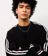 Buzo masculino de fleece con felpa, color negro con diseño boxy, mangas largas y rayas blancas contrastantes a lo largo de las mangas.