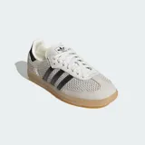 Championes Adidas Samba OG con diseño de malla transpirable y detalles en cuero. Presenta las icónicas tres bandas laterales en negro, puntera reforzada y suela de goma color caramelo.