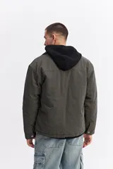 Campera de canvas color gris oscuro con cuello camisero, cierre frontal y bolsillo con cierre en el pecho. Presenta un diseño de estructura firme con estilo utilitario.