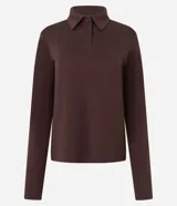 Blusa tipo polo de manga larga, confeccionada en tejido interlock de algodón y poliéster. Presenta cuello clásico con cierre frontal de botones y diseño básico liso.