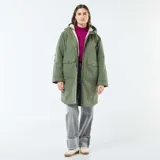 Parka larga de color verde con capucha ajustable mediante cordones y forro interior de efecto borreguito. Presenta un cierre frontal de cremallera oculto por una solapa con botones a presión y dos bolsillos grandes de parche con solapa en el frente.
