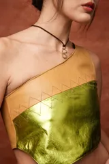 Top color crema de cuero sintético, con un solo tirante ancho y corte asimétrico.