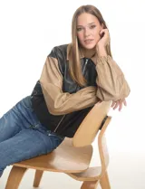 Chaqueta bomber de eco cuero color verde oliva, con cuello tipo solapa, cierre frontal metálico, bolsillos laterales y puños elásticos.