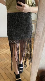 Falda tejida a mano en crochet, color crudo, con flecos en el ruedo y abertura lateral.