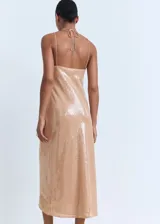 Vestido midi de lentejuelas color tostado, sin mangas, con cuello halter, tirantes finos ajustables con lazo en el cuello y diseño recto.