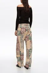 Pantalón balloon de tiro medio confeccionado en algodón, con diseño estampado tipo patchwork en tonos beige, marrón y verde, corte abotinado y bolsillos laterales.