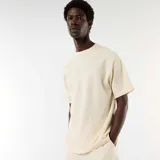 Camiseta de manga corta en tejido nido de abeja color blanco, de corte estándar y cuello redondo.
