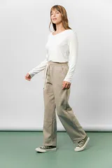 Pantalón deportivo de corte wide leg con caída relajada. Presenta cintura elastizada con cordón ajustable, bolsillos laterales y un interior frizado para mayor abrigo.