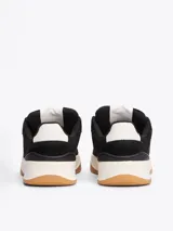 Zapatillas Tommy Jeans de corte bajo, color negro, con exterior de ante, interior de poliéster y suela de goma color caramelo. Presentan un panel a contraste en el talón, logo de Tommy Jeans en la lengüeta y etiqueta de la marca en el lateral.