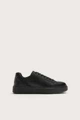 Zapatilla deportiva monocolor de diseño minimalista, con cordones y suela de plataforma con volumen.