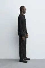 Pantalón chino de corte ajustado, color beige, con bolsillos laterales y bolsillos traseros de vivo. Cuenta con cierre frontal de cremallera y botón.