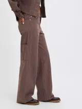 Pantalón wide leg marrón de tiro medio con diseño de rayas diplomáticas verticales blancas.