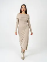 Vestido midi de punto color camel, con escote estilo bote con solapa caída y mangas largas ajustadas. Presenta un corte entallado que sigue la silueta del cuerpo.