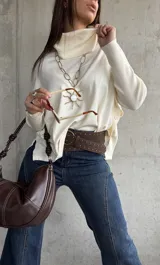 Sweater de punto color natural con cuello polera, manga larga y diseño holgado.