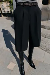 Bermuda larga color marrón oscuro, tiro medio, con pinzas frontales y cinturón de textura animal print plateado.