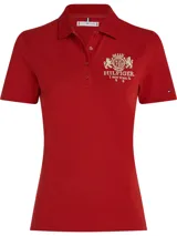 Chomba roja de algodón con elastano, corte slim, cuello polo y cartera de cuatro botones. Tiene un logo bordado en el pecho y la bandera de Tommy Hilfiger bordada en la manga.